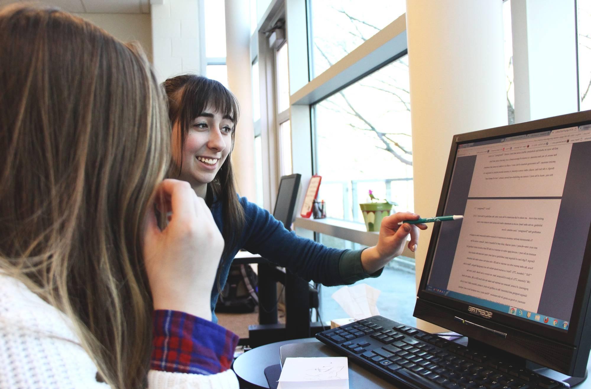 A writing consultant and a student working together at a computer